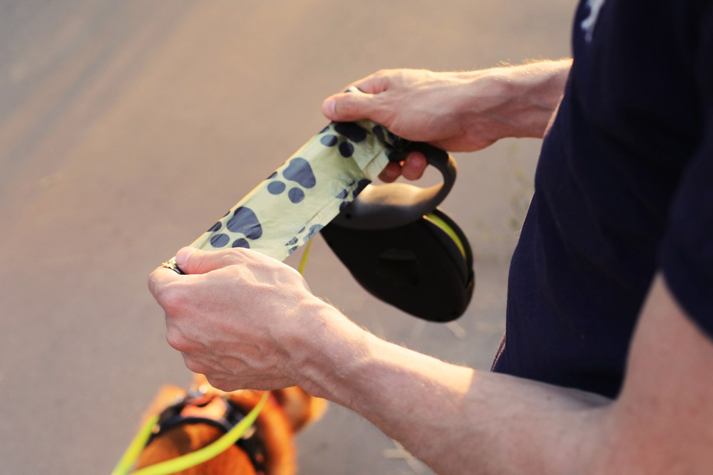 man holding a poop bag outdoor