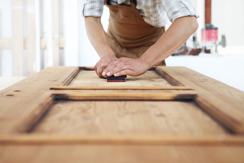 man fixing wooden door