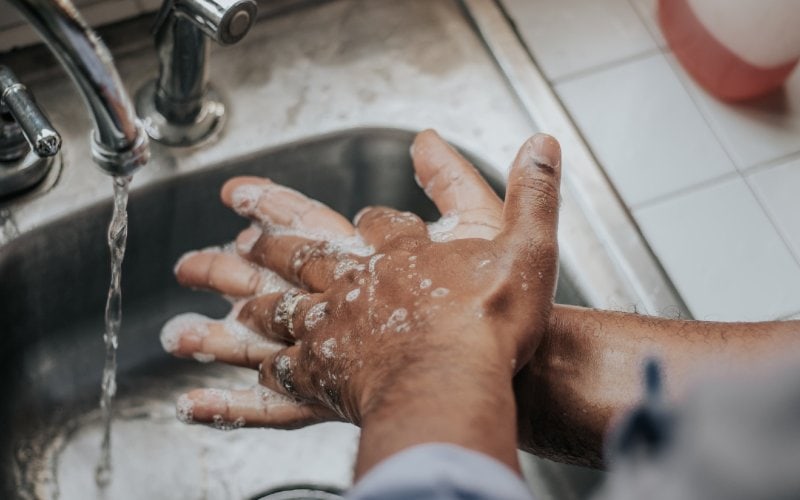 man washing his hands in the sink