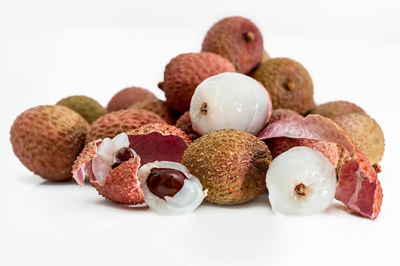 peeled lychees on white background