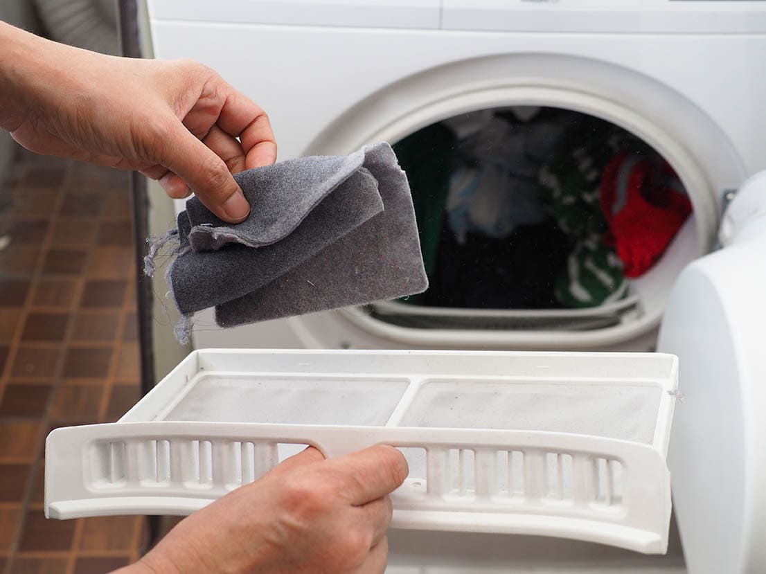 person holding lint remover from the washing machine