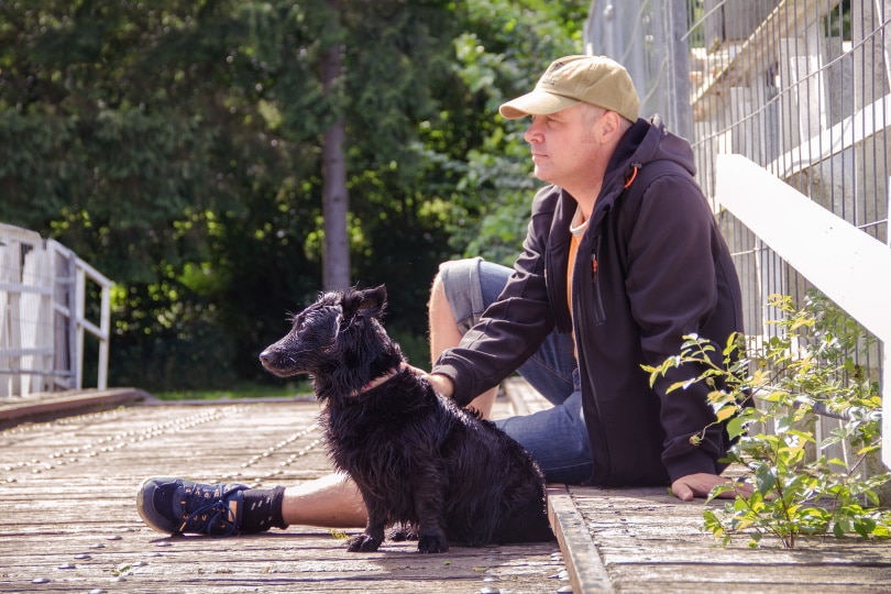pet owner sitting beside his dog