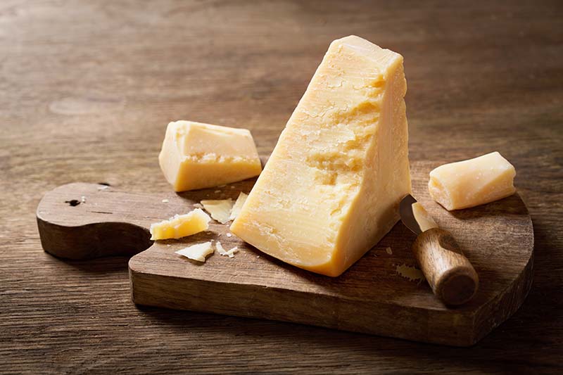 piece of parmesan cheese on a wooden board