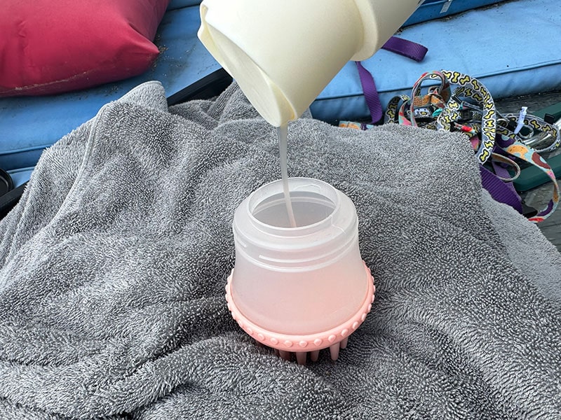 pouring maxbone calming shampoo in shampoo dispensing brush