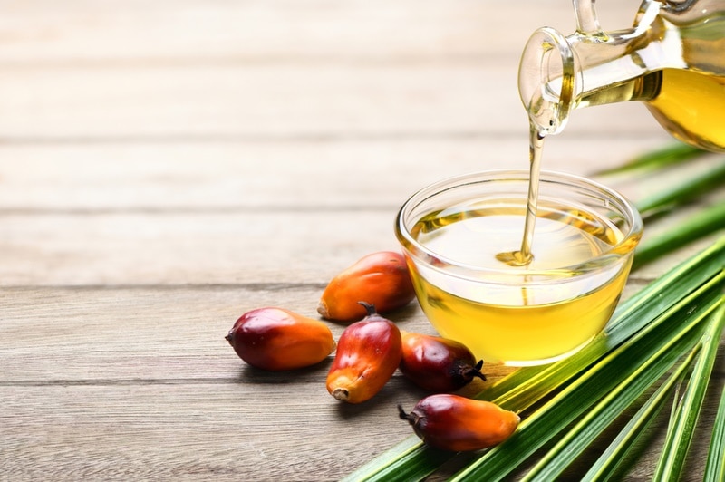 pouring palm oil into glass bowl