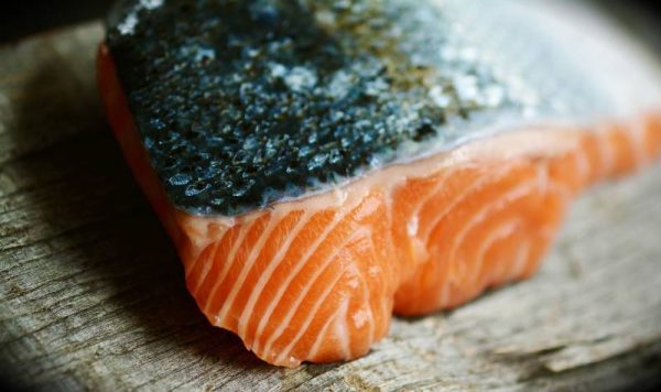 raw salmon meat on wooden board