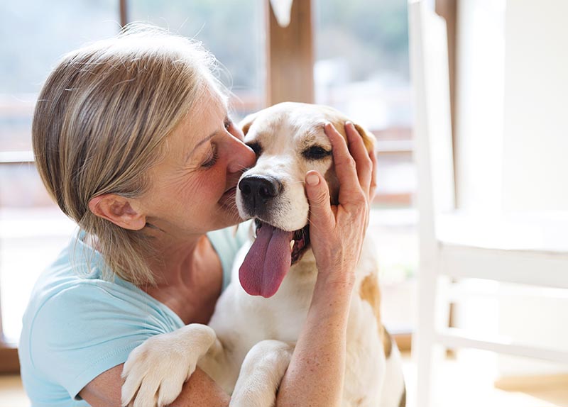 senior woman cuddling with her dog