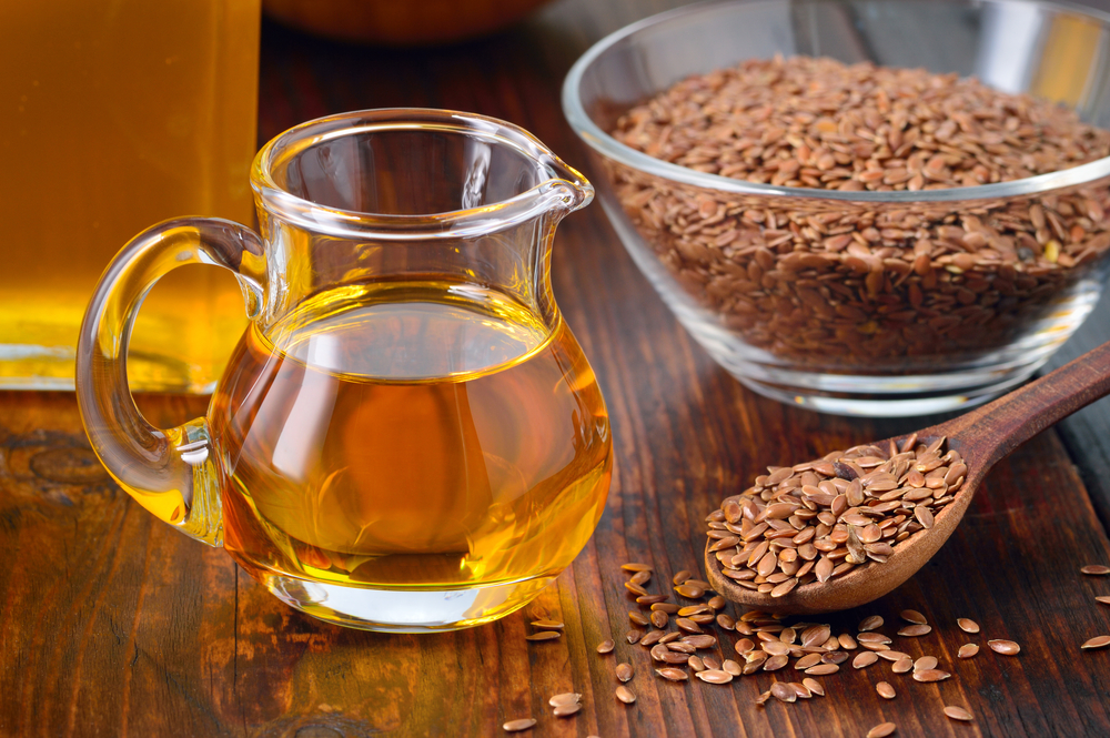 Brown flax seeds on spoon and flaxseed oil