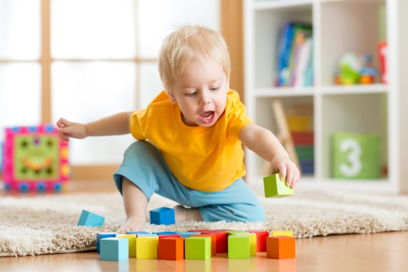 toddler playing wooden toys at home