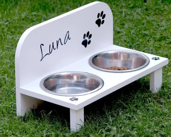 white raised wooden dog feeder on grass