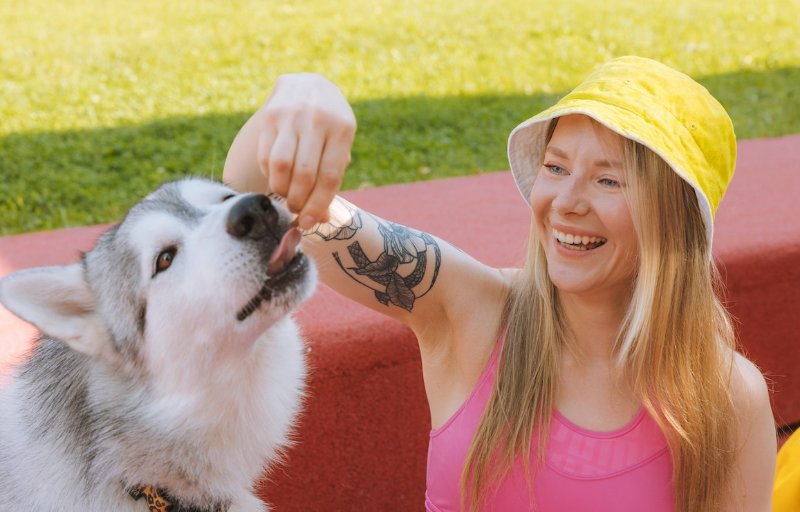 woman giving a treat to her dog outdoors