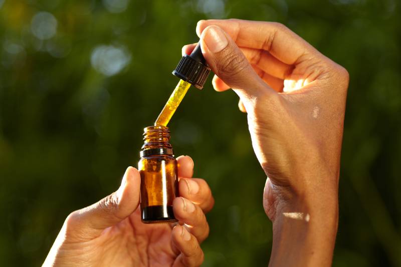 woman holding a dropper with an oil product