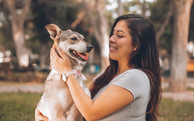 woman holding her dog outdoors