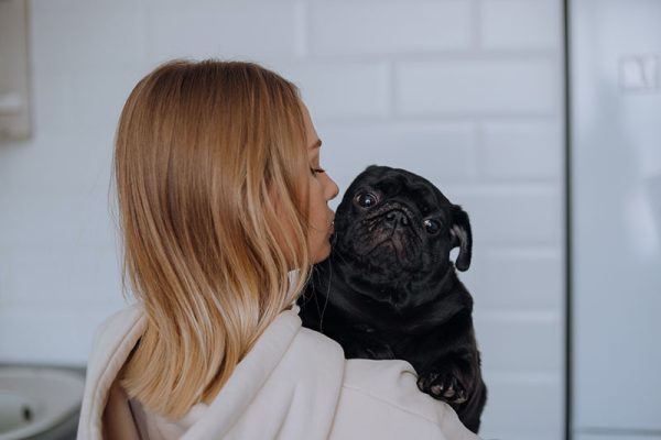 woman hugging a pug