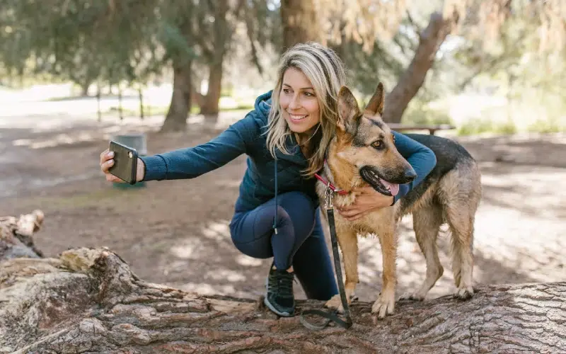 woman taking a picture with a dog
