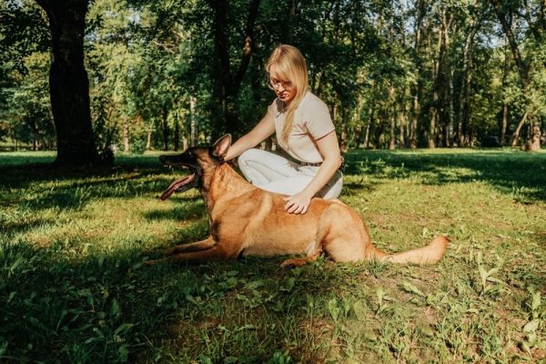 woman with belgian malinois at the park