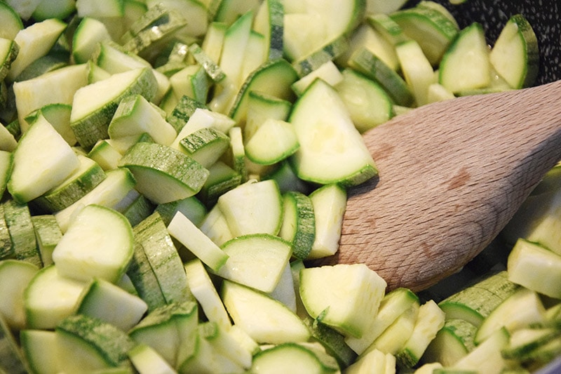 wooden spoon on sliced zucchinis