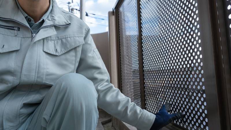 worker inspecting the fence on the balcony