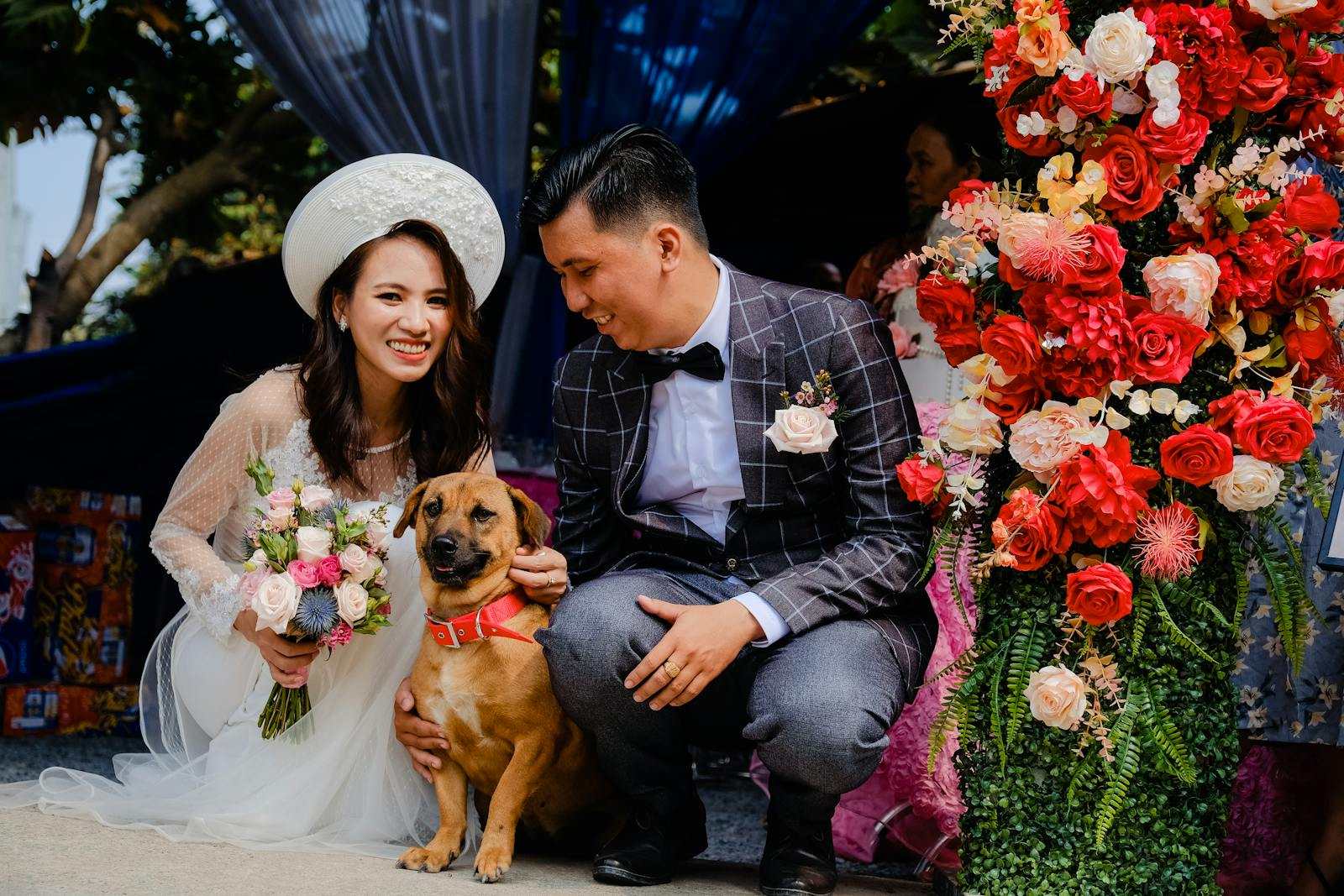 Glad Asian newlywed couple with dog on wedding day