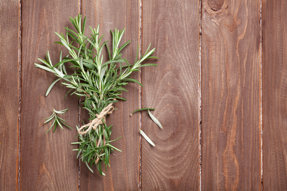 Fresh garden rosemary on wooden table