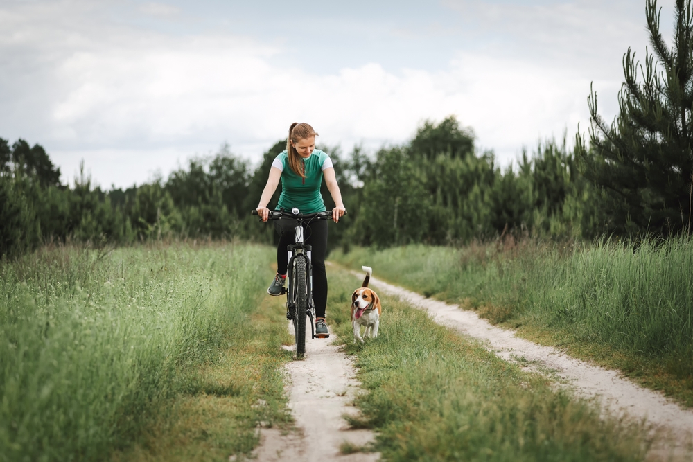 Woman cycling with a dog