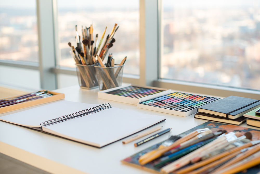 art materials on the desk near the window