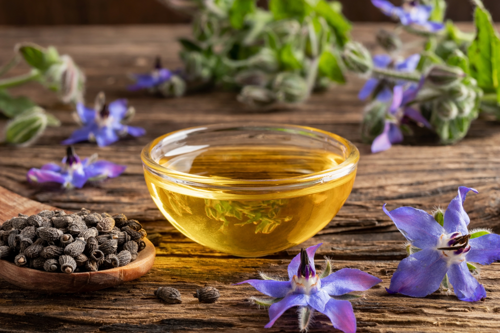 bowl of borage oil with seeds and flowers