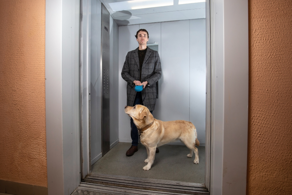 man with labrador dog inside the elevator