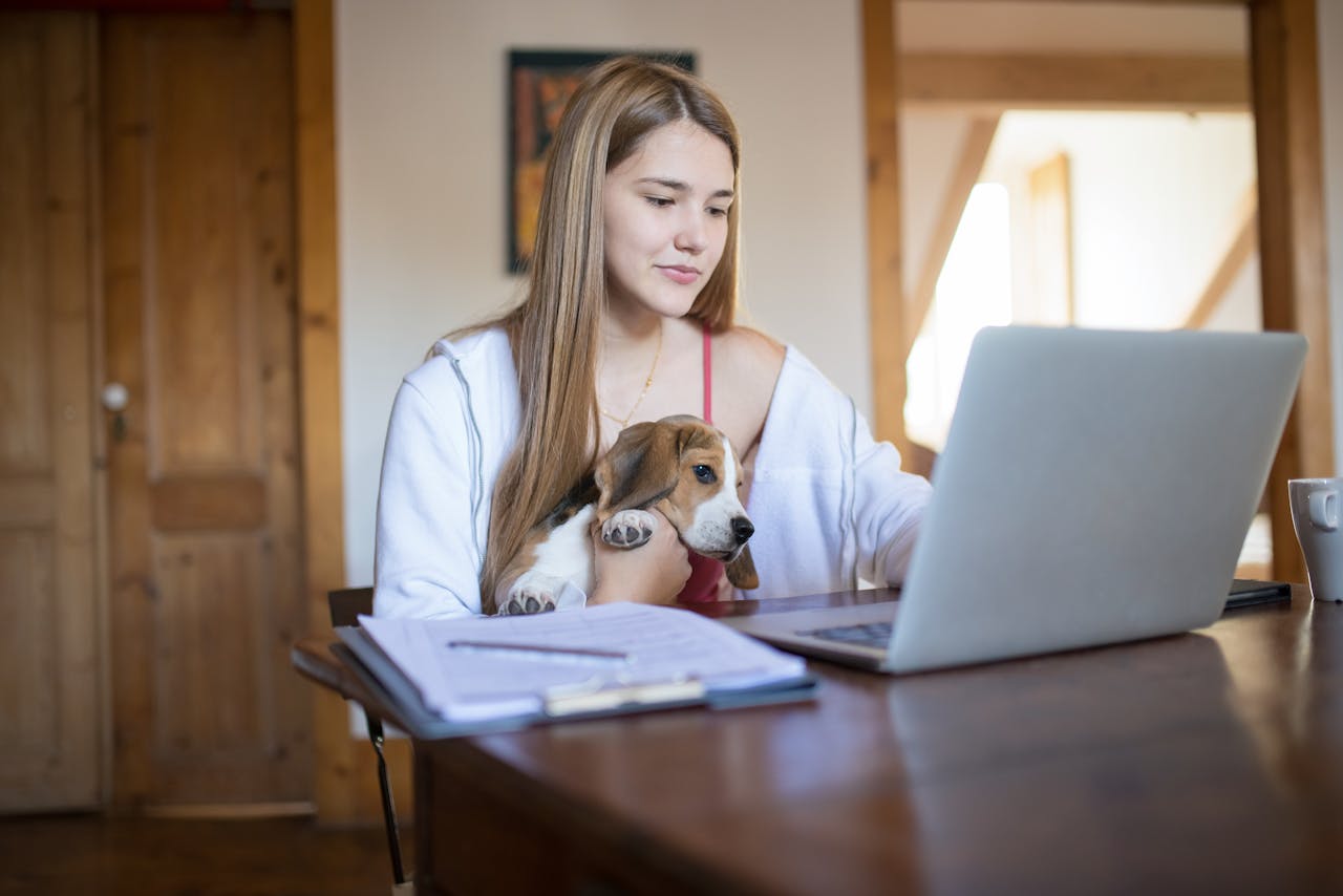 woman with her dog working on laptop