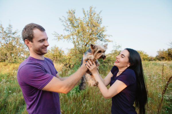 Man handing puppy to a woman