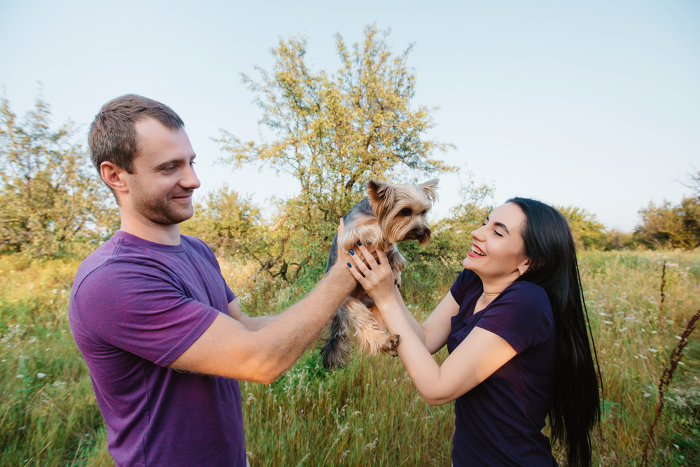 Man handing puppy to a woman