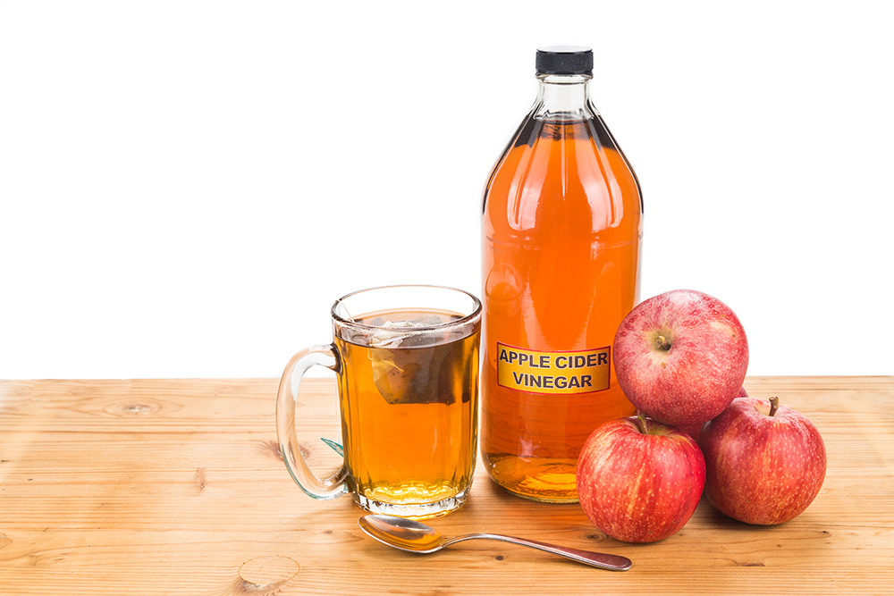 a cup and bottle of apple cider vinegar