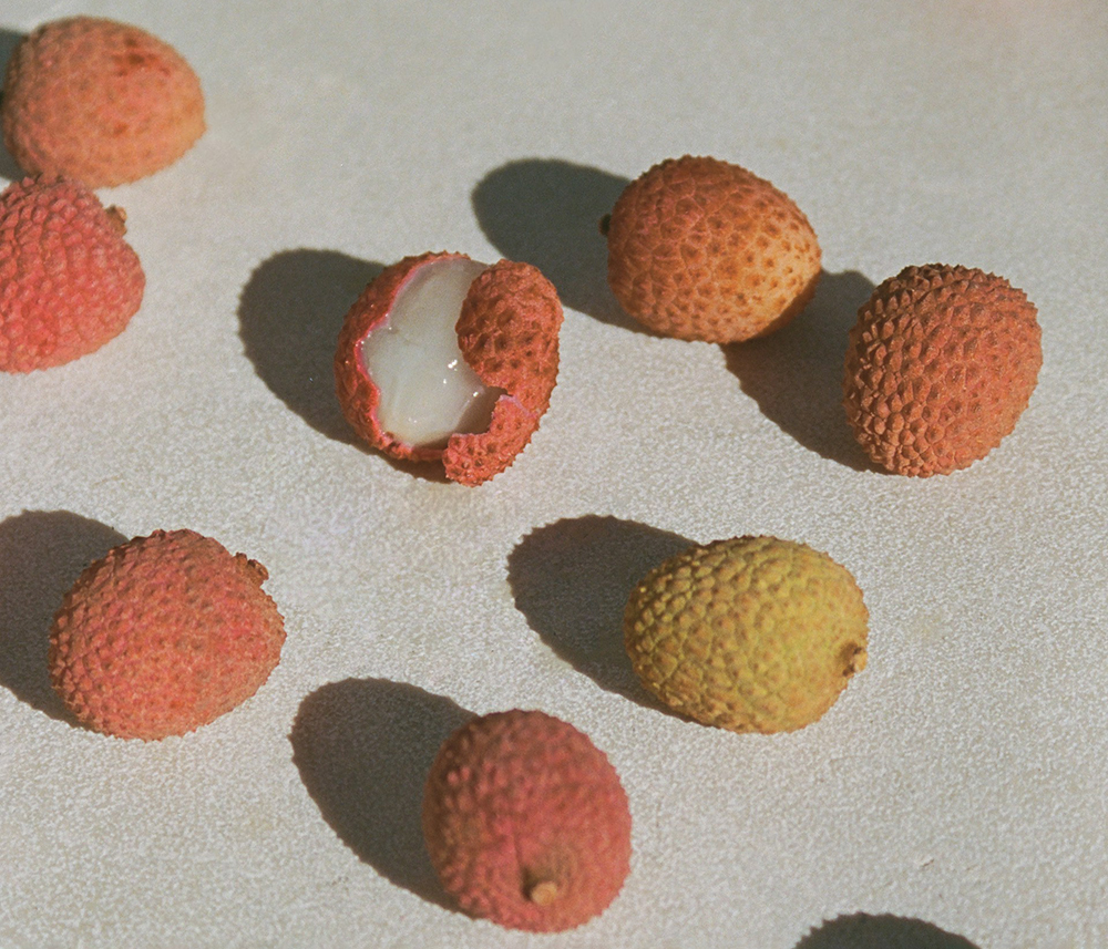 a peeled lychee in the midst of other lychees