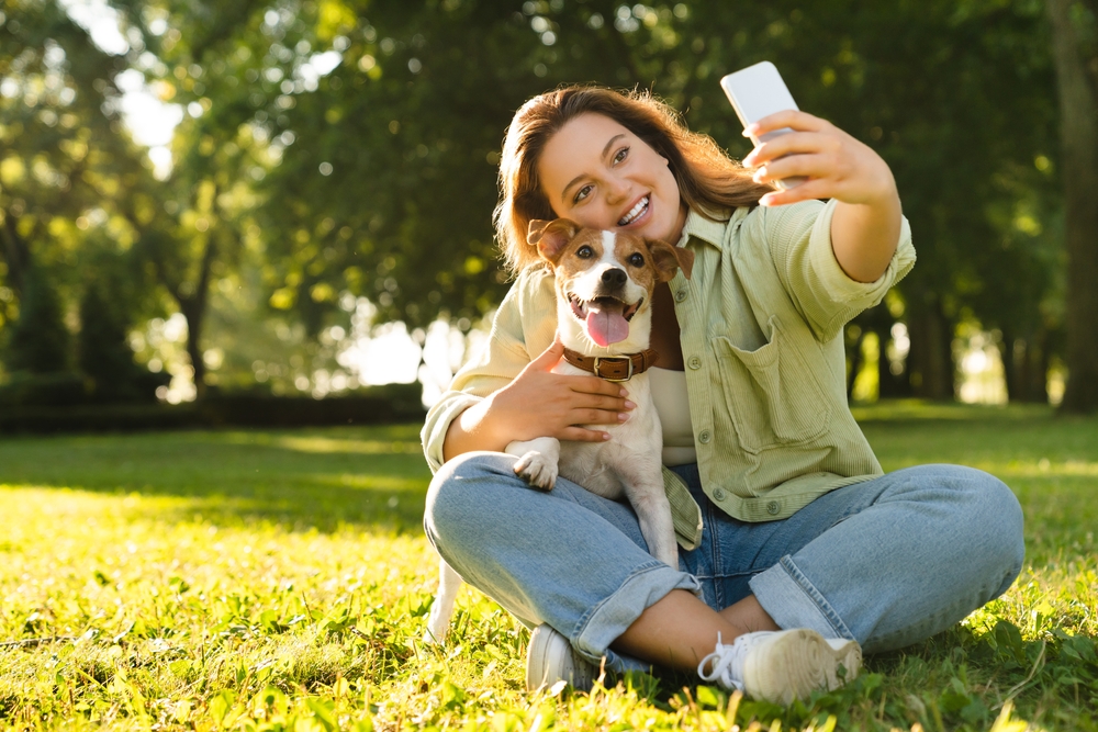 woman taking selfie photo image on smart phone with jack russell terrier dog