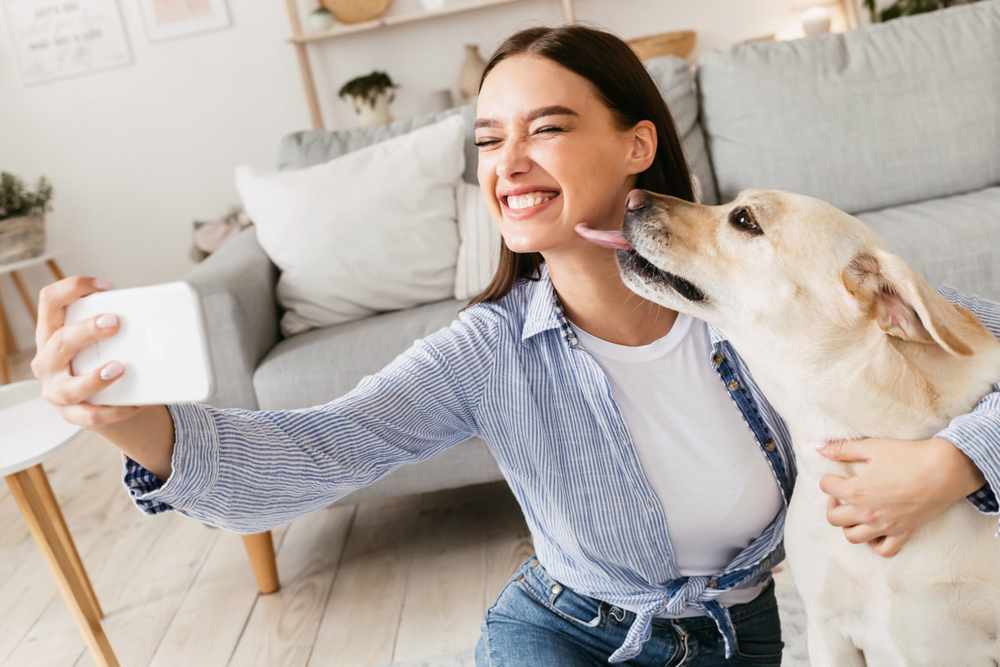 woman taking selfie with her dog at home