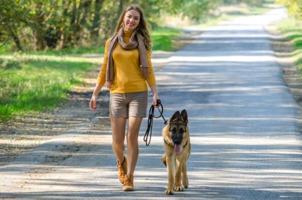 woman-walking-with-her-german-shepherd-at-the-park