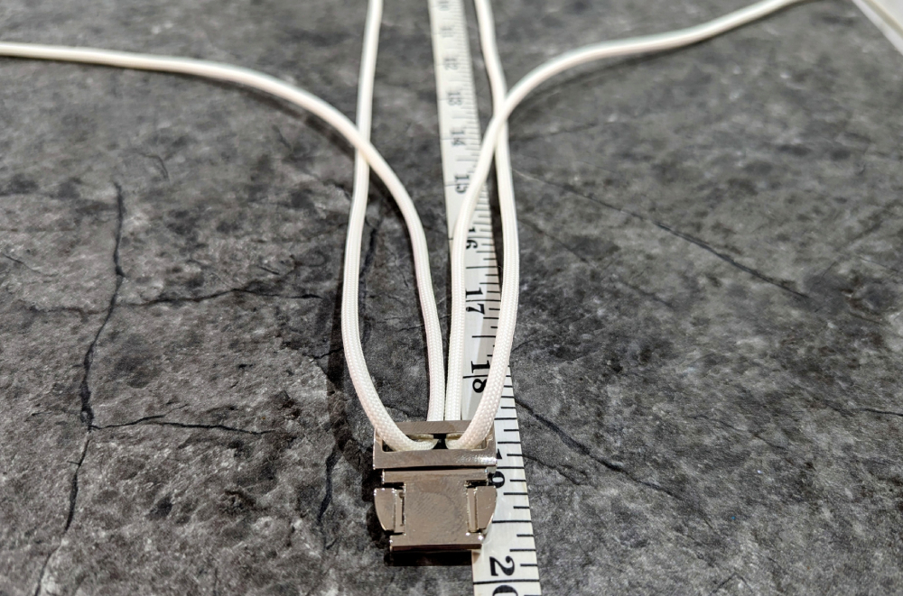9. Place the long ends between the cord running between the buckle pieces