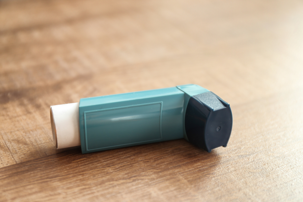 Asthma inhaler on wooden table