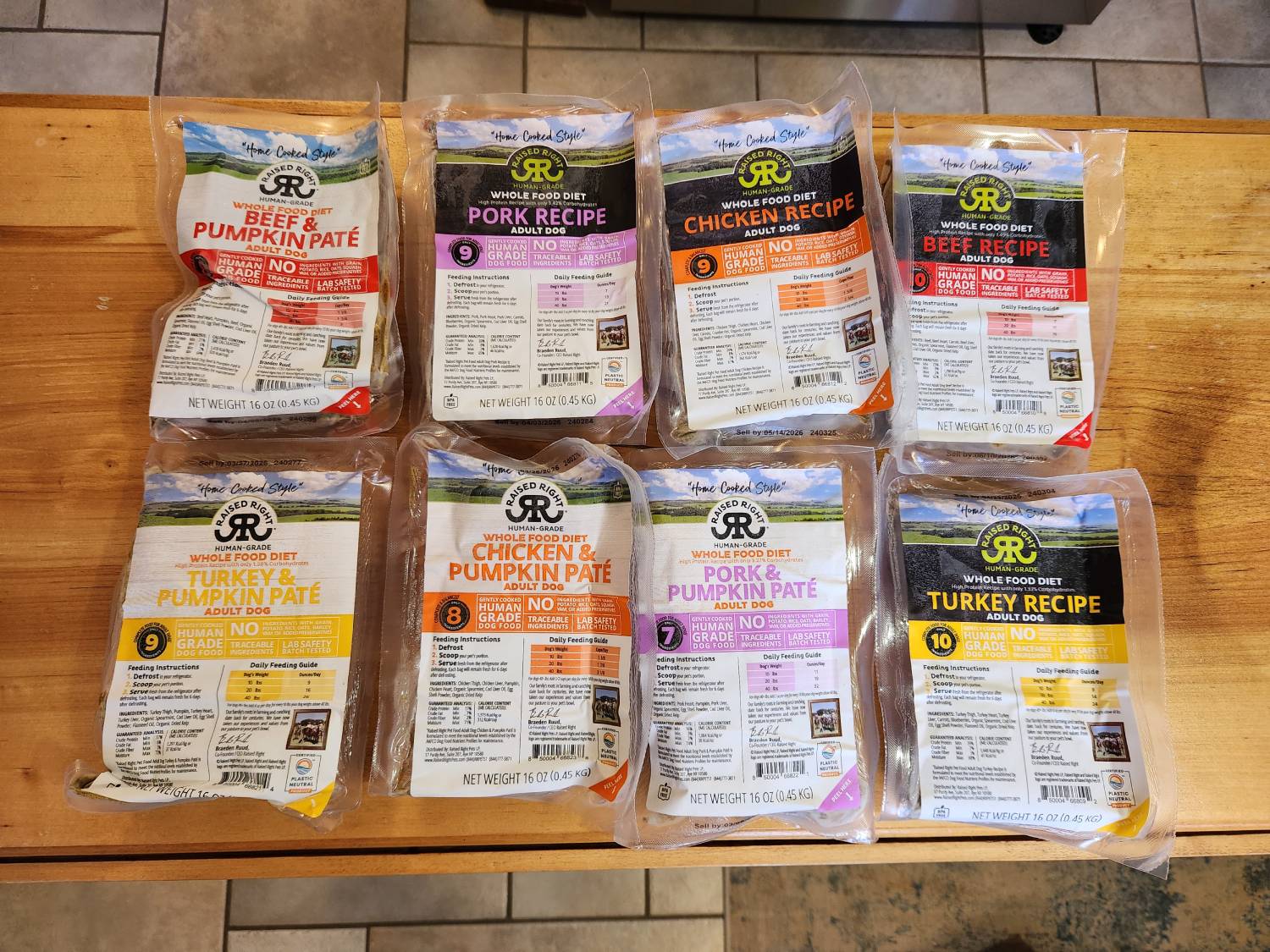 Raised Right Human Grade Dog Food Review - eight recipes on wooden table
